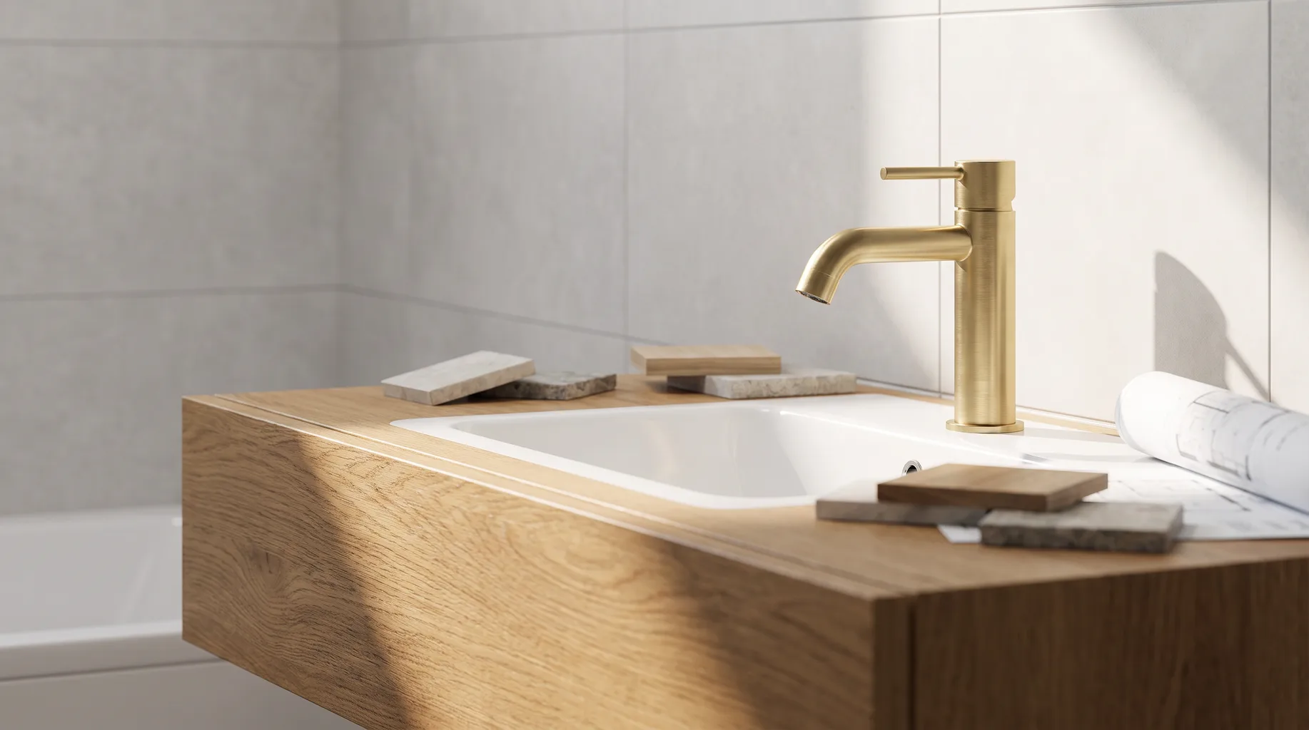 Close-up of a brushed brass deck-mounted basin mixer tap above a floating oak vanity unit in a newer commuter-belt Twyford house bathroom, bright directional daylight.