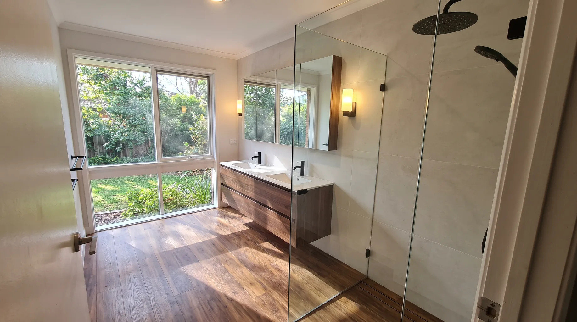 Finished modern Finchampstead bathroom with a twin-basin wall-hung vanity, walnut timber flooring and a matte black wet-room shower screen