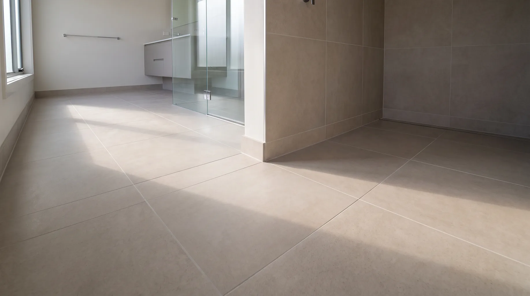 Finished luxury bathroom with a continuous flat large format porcelain floor and wall run, joints lining through from floor to wall with no visible lippage