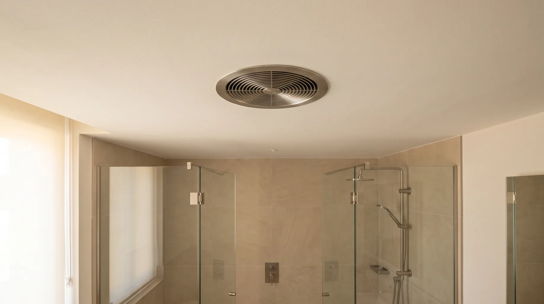 Finished luxury bathroom with a circular flush-mounted extractor fan grille set neatly into the painted ceiling above a walk-in shower enclosure