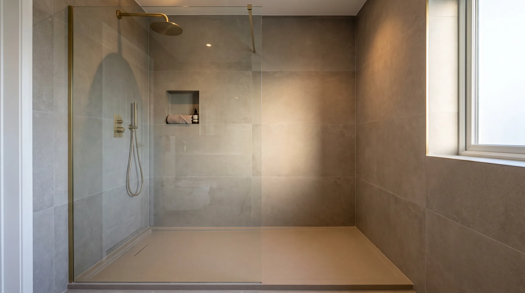 Finished walk-in shower with fixed glass panel, low-profile stone resin tray and overhead rainfall shower head