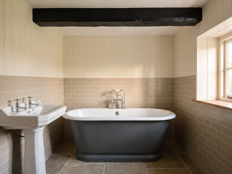 Finished bathroom with an exposed painted timber ceiling beam and tiled wainscoting in a Binfield period cottage