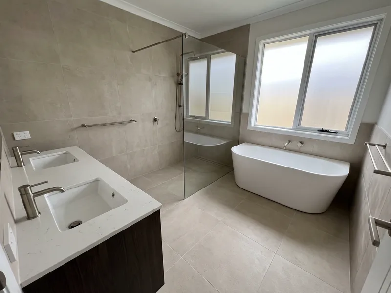 Finished principal en-suite bathroom typical of a larger detached Sunninghill home with a walk-in shower, double vanity and freestanding bath