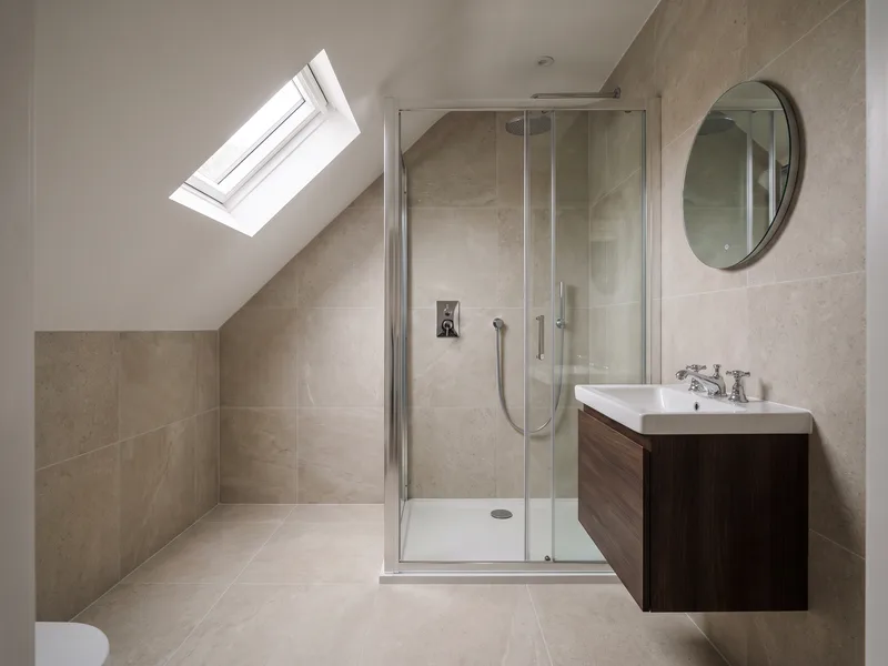 Finished bathroom under a sloped period town-house ceiling with a framed glass walk-in shower in Windsor